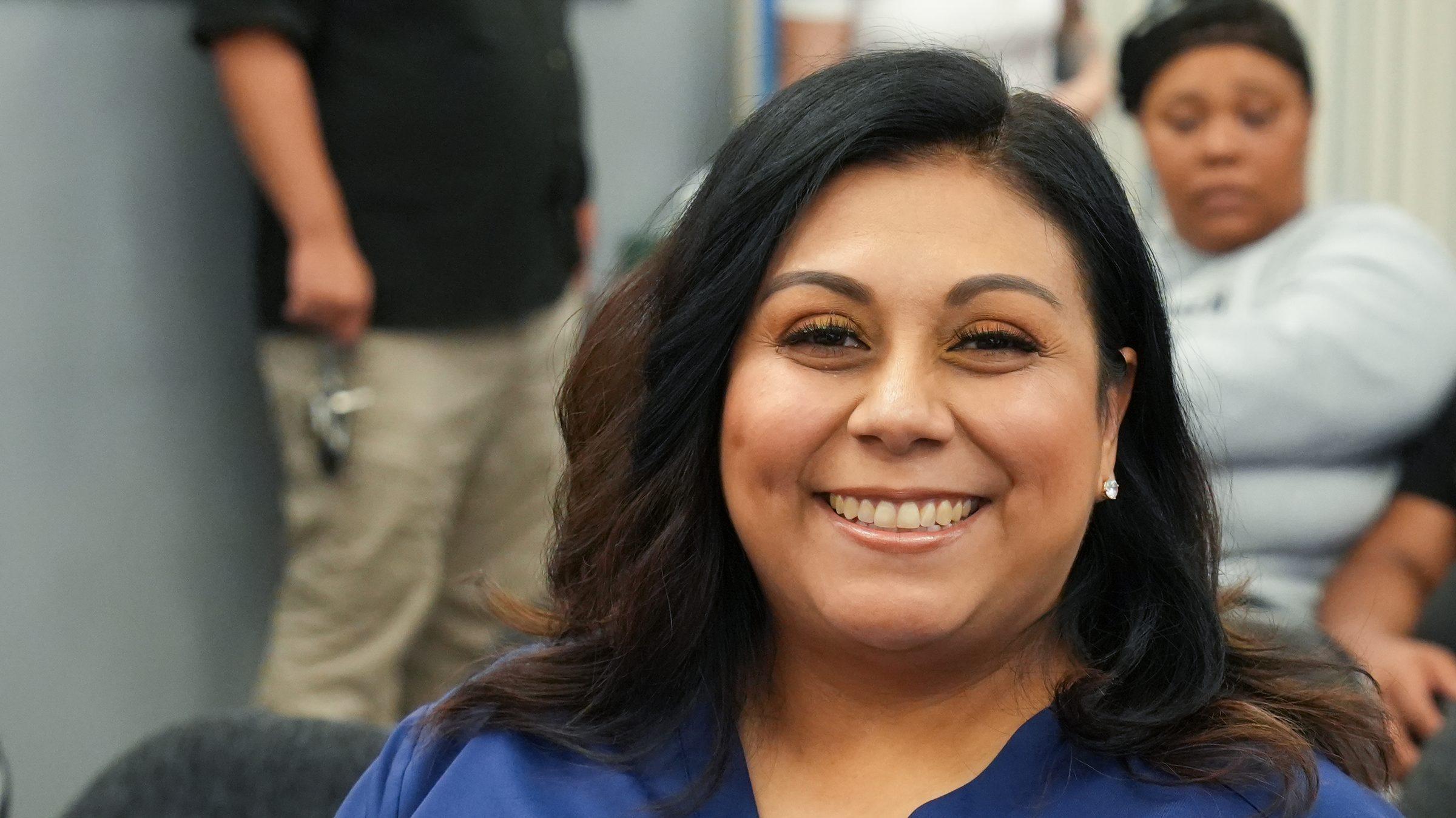 A smiling community member in Career Technical Education attire at a Highlands Forward event.